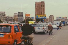 Motorists in Cairo. A scooter and a car share a lane on a roadway in Cairo