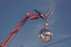 A photo of a crane holding a shiny wrecking ball above a street, shot by Lance Anderson and accessed via Unsplash.com